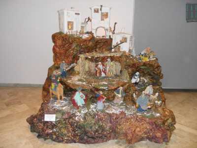 Un presepe ricavato dal tronco di un albero, adagiato sul pavimento del Museo